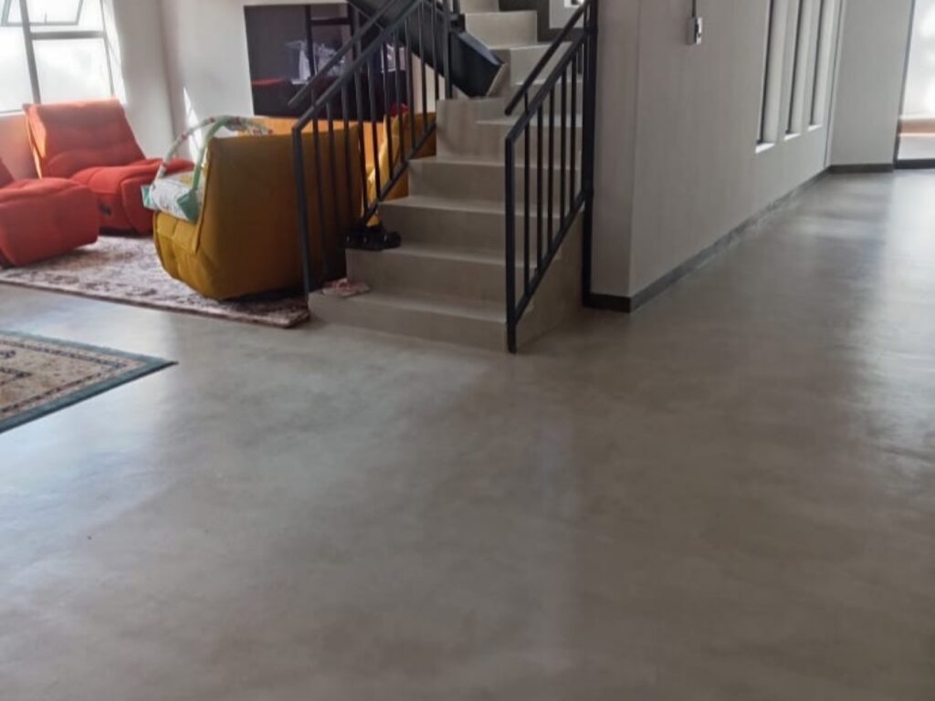 Seamless epoxy floor running through a home entrance and staircase