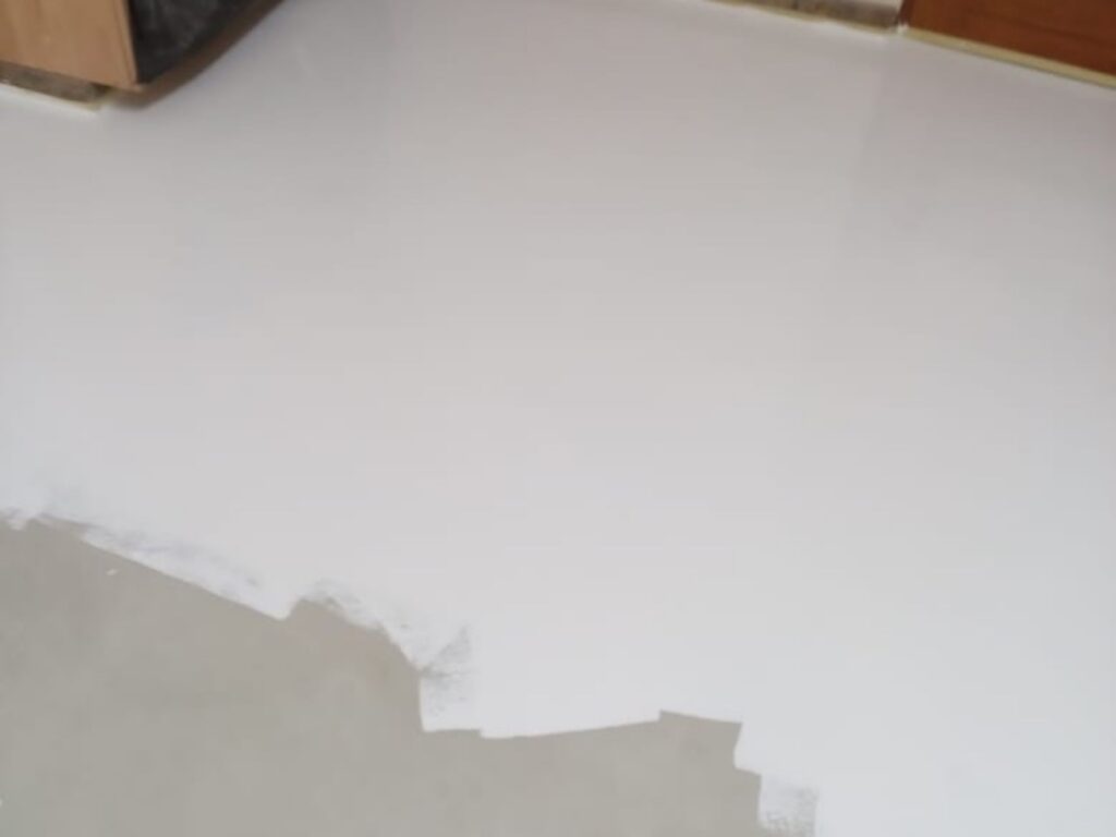 Waterproof membrane being applied to a prepared interior floor